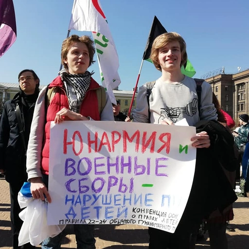 Участни:цы Движения с плакатом "Юнармия и военные сборы – нарушение прав детей".